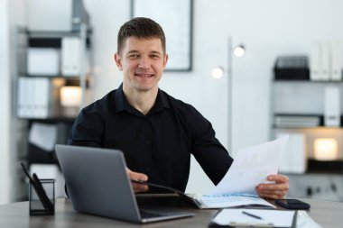 Ofisteki masasında belgelerle çalışan yakışıklı bir adam. Metin için boşluk