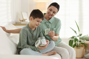 Annem evdeki kanepede oğluna harçlık veriyor.