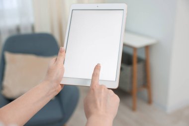 Evde modern tabletli bir kadın, yakın plan.