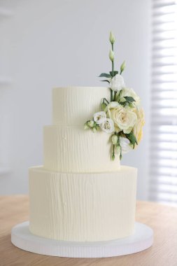 İçerideki ahşap masada çiçek desenli nefis düğün pastası.