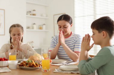 Aile akşam yemeğinden önce evde dua ediyor.