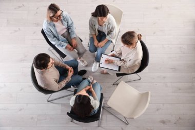 İçeride psikoterapi gören bir grup insan.