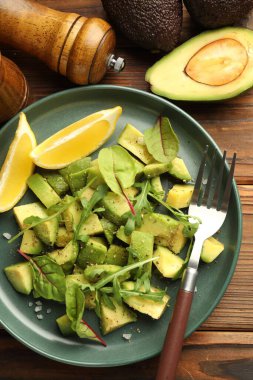 Lezzetli avokado roka, limon ve ahşap masa üzerinde sos, düz yatıyordu.