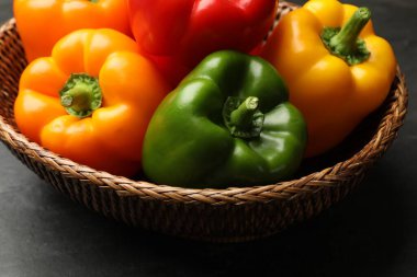 Taze renkli dolmalık biberler sepetin içinde karanlık masada, yakın plan.