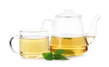 Cam fincanda aromatik limon merhemi çayı, çaydanlık ve beyaz üzerine izole edilmiş taze yapraklar.