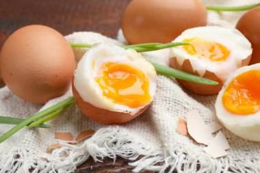 Ahşap masada yeşil soğanlı kaynamış yumurta, yakın plan.