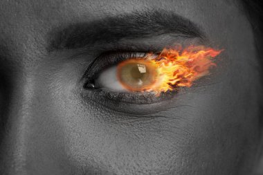 Gözünde ateş yanan bir kadın, yakın çekim. Siyah ve beyaz etkisi