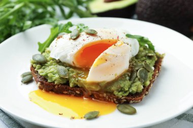 Avokadolu lezzetli sandviç, haşlanmış yumurta, roka ve balkabağı, yakın plan.