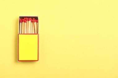 Sarı arka planda kutuda kibrit var, en üstte. Tasarım için model