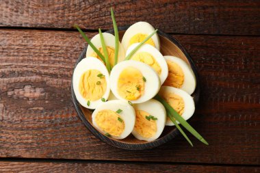 Haşlanmış yumurta ve ahşap masada yeşil soğan.