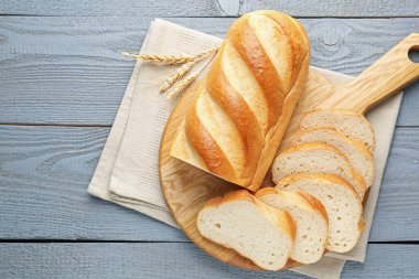 Gri ahşap masada bir somun ekmek ve dikenler kes.