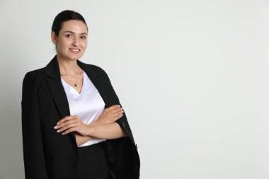 Hafif arka planda takım elbiseli kendine güvenen bir iş kadını. Metin için boşluk