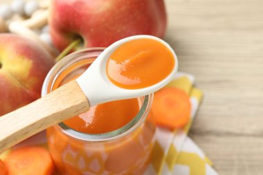 Bebek maması. Kavanozda lezzetli püre, malzemeler ve kaşık masada, yakın plan. Metin için boşluk