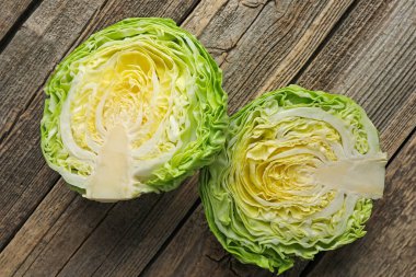 Tahta masanın üzerinde taze lahana yarımları, düz uzanmış.