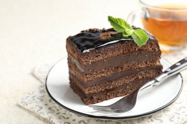 Nane, çatal ve çayla servis edilen çikolatalı kek, yakın plan.