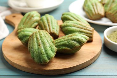 Açık mavi ahşap masada nefis kibrit makarnalı kekler, yakın plan.