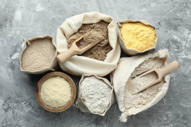 Gri desenli sehpada, düz yerde duran farklı tipte un var.