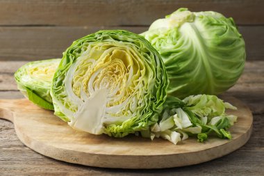 Ahşap masada kesim ve tüm lahanalar, yakın plan.