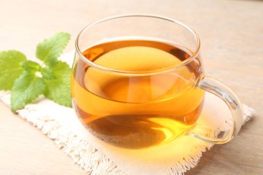 Cam bardakta Aromatik limon merhemi çayı ve masada taze yapraklar, yakın plan.