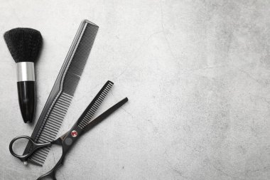 Gri masadaki farklı kuaför aletleri, düz yatış. Metin için boşluk