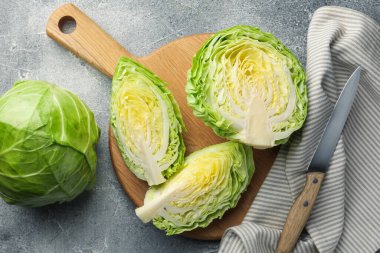 Taze lahana ve bıçak gri masada, düz yatıyordu.