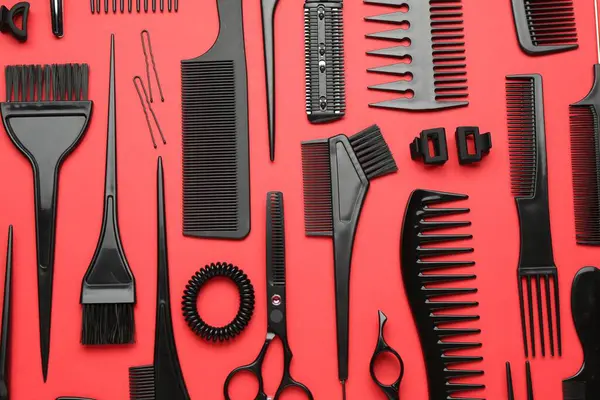 Kırmızı arka planda farklı kuaför aletleri, düz yatıyordu