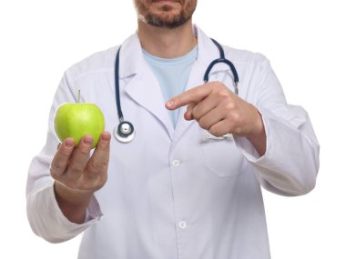 Beyaz arka planda yeşil elmalı ve steteskoplu beslenme uzmanı, yakın plan.