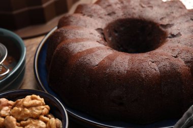 Lezzetli çikolatalı kek ve cevizler masada, yakın plan.