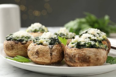 Beyaz masada servis edilen lezzetli mantarlar bulanık arka plan, yakın plan