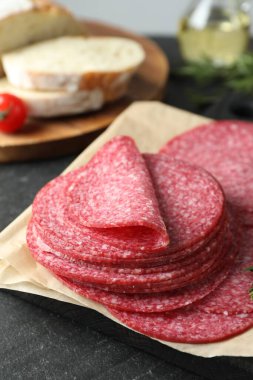 Lezzetli füme sosis dilimleri siyah masada, yakın plan.