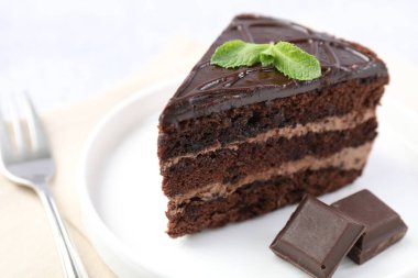 Nefis bir parça pasta, nane ve çikolata ışık masasında, yakın plan.