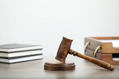 Yargıç tokmağı ve kitaplar ofisteki ahşap masada, yakın plan.