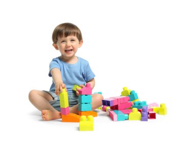 Beyaz arka planda tuğlalarla oynayan sevimli küçük çocuk.