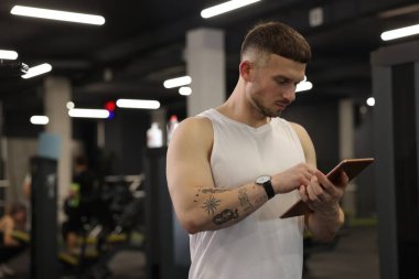 Spor merkezinde tableti olan kişisel antrenör. Metin için boşluk