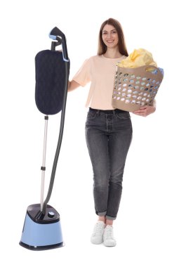 Duran buharlı gülen kadın ve beyaz arka planda giysileri olan sepet.