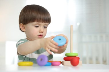 Masada oyuncak piramidiyle oynayan sevimli küçük çocuk.