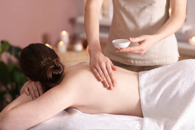 Spa salonunda kadın sırt masajı yaptırıyor.