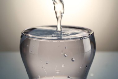 Gri gradyan arkaplanda cama su dökülüyor, yakın plan