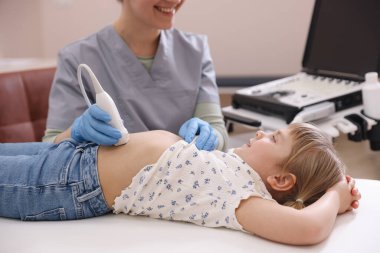 Sonograf, klinikte küçük bir kızın karın ultrasonu muayenesi yapıyor.