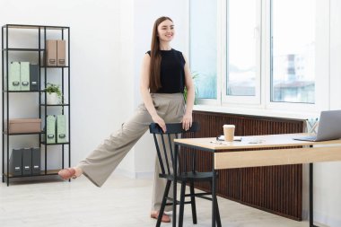 Sandalyede egzersiz yapan güzel bir kadın.