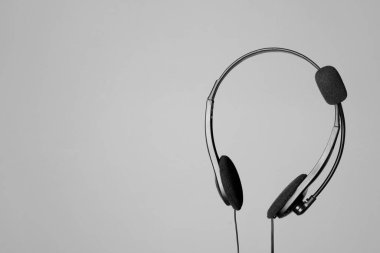 Açık gri arkaplanda mikrofonlu kulaklık, metin için boşluk