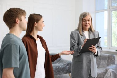 Gülümseyen emlakçı evde çiftlerle çalışıyor.