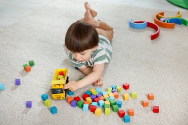 Evde renkli küpleri ile oynayan sevimli küçük çocuk