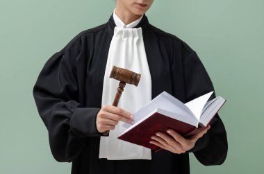 Açık yeşil arkaplan üzerine kitap ve çekiçle yargıç, yakın plan