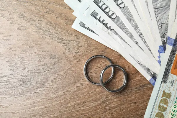 Gümüş alyanslar ve bir dolarlık banknotlar. Metin için boşluk