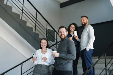 Mesai arkadaşları kahve molası sırasında ofislerinde kahve içerler.