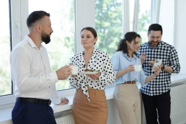 Yemek ve içeceklerle iş arkadaşları öğle arasında ofiste pencere kenarında.