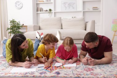 Ebeveynler çocuklarına evde yerde çizim yapmayı öğretiyor.