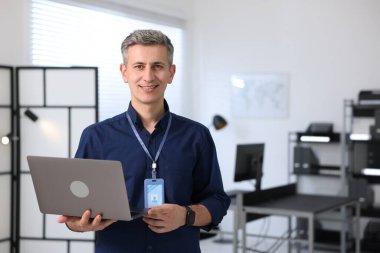 Ofiste dizüstü bilgisayarla gülümseyen mühendisin portresi. Metin için boşluk