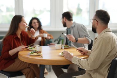 İş arkadaşları öğle arasında ofiste sohbet ediyorlar.
